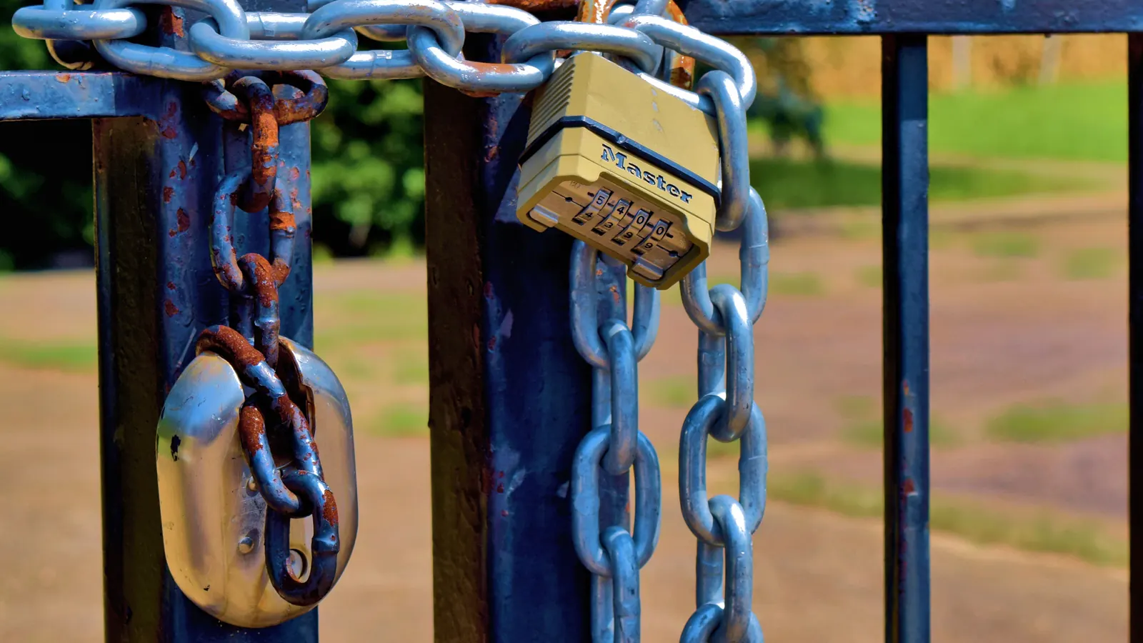 Padlock and chain on a blue gate